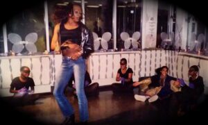 Woman dancing confidently in front of seated spectators.
