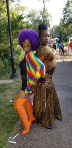 Two individuals in vibrant, bold outfits posing confidently outdoors.