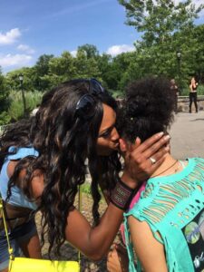 Two people sharing a heartfelt moment outdoors in the sunshine.