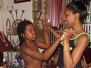 Two women dancing closely indoors, sharing an expressive moment.