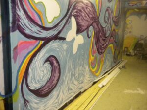 Colorful abstract mural with swirling shapes on a wall.